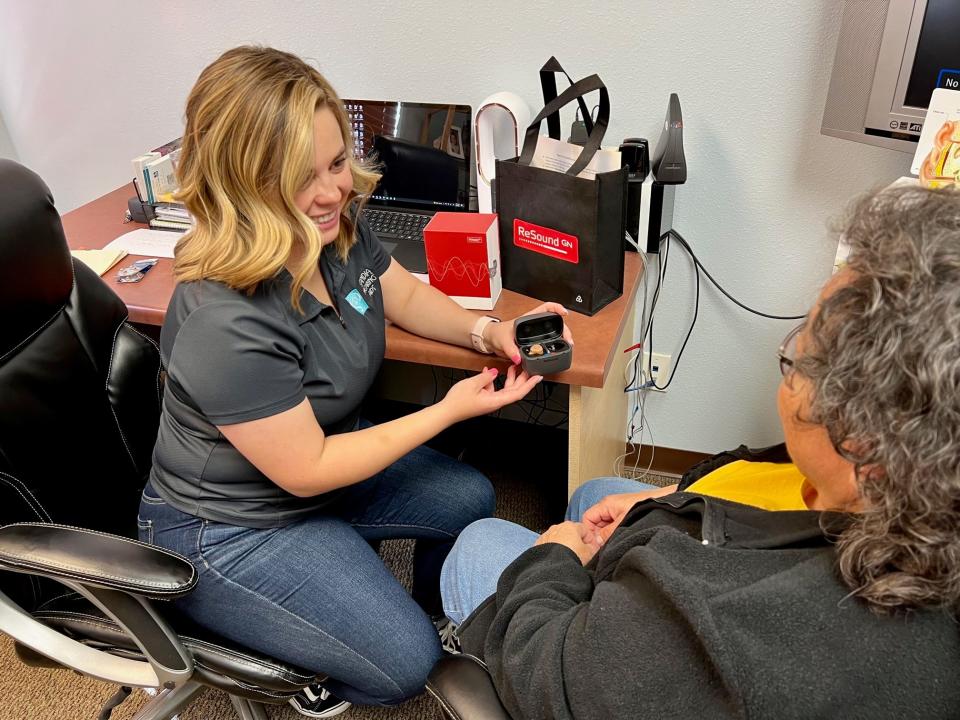 Alexandria Hamblin, hearing instrument specialist,  showing L.B. how to charge her new Resound, ONE Custom rechargeable hearing aids.