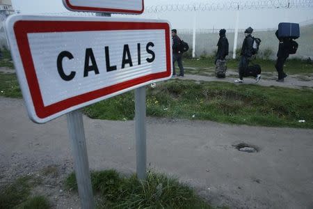 Migrants carry their belongings at the start of their evacuation and transfer to reception centers in France, and the dismantlement of the camp called the "Jungle" in Calais, France, October 24, 2016. REUTERS/Pascal Rossignol