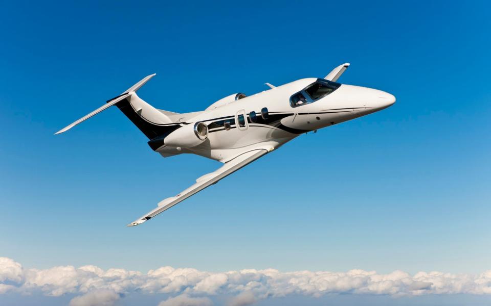 Pilots flying corporate jet above the clouds in clear blue skies. - RaptTV/Corbis RF Stills