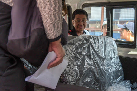 Maria Ressa, head of Philippine news website Rappler, is seen in a vehicle with police upon arrival at Manila airport on Friday March 29, 2019 in this handout photo. Leanne Jazul/Rappler/Handout via REUTERS