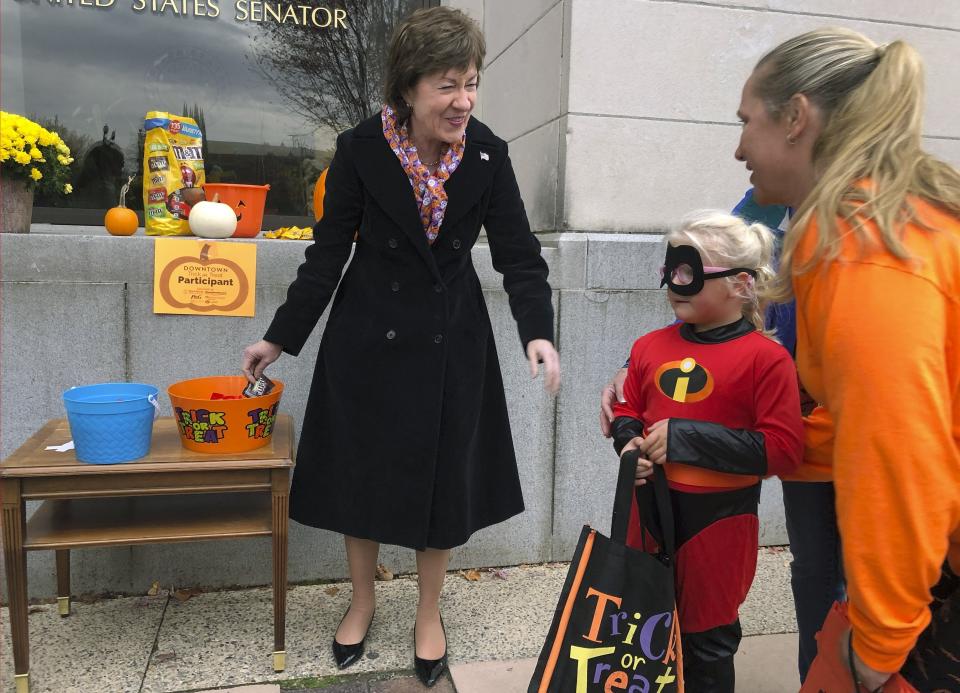 In this Friday, Oct. 25, 2019 photo, Sen. Susan Collins, R-Maine, hands out candy to children outside her office during a tricks-or-treat event hosted by the local chamber of commerce in Lewiston, Maine. Collins is expected to make a formal announcement on her reelection plans later this fall. (AP Photo/David Sharp)