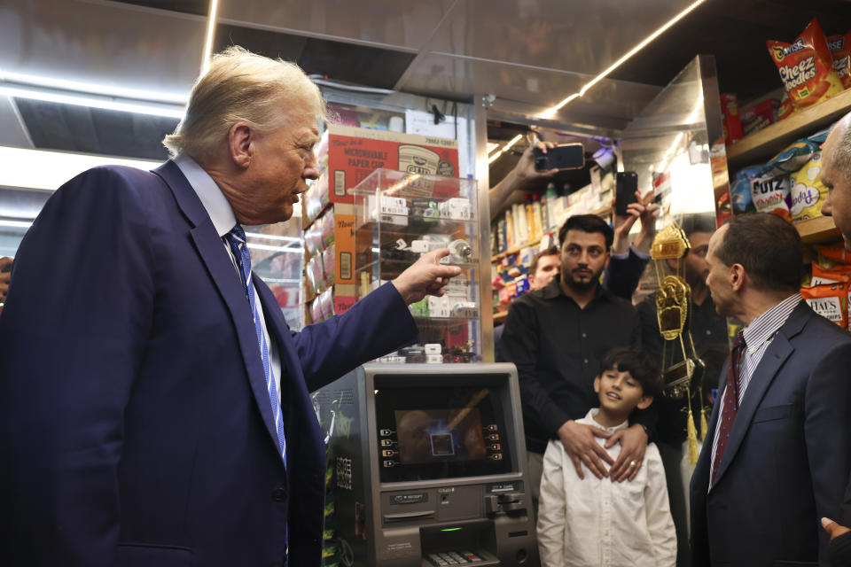 Former president Donald Trump talks with bodega owner Maad Ahmed, center, during a visit to his store, Tuesday, April 16, 2024, in New York. Fresh from a Manhattan courtroom, Donald Trump visited a New York bodega where a man was stabbed to death, a stark pivot for the former president as he juggles being a criminal defendant and the Republican challenger intent on blaming President Joe Biden for crime. (AP Photo/Yuki Iwamura)