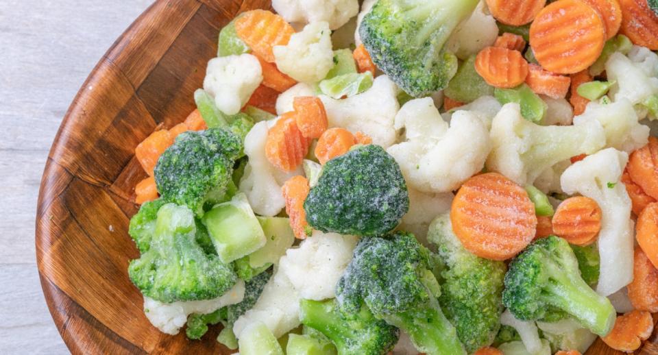 Mixed frozen vegetables in wooden bowl
