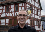 Thomas Metzmacher stands in front of his apple cider restaurant 'Zum Lahmen Esel' in Frankfurt, Germany, Friday, April 3, 2020. Due to the coronavirus outbreak the restaurant which has been in operation since 1807 offers cider and food to go in a self-made drive through set up. (AP Photo/Michael Probst)
