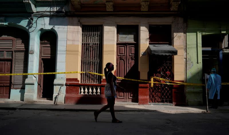 FILE PHOTO: A woman walks past houses in quarantine in Havana