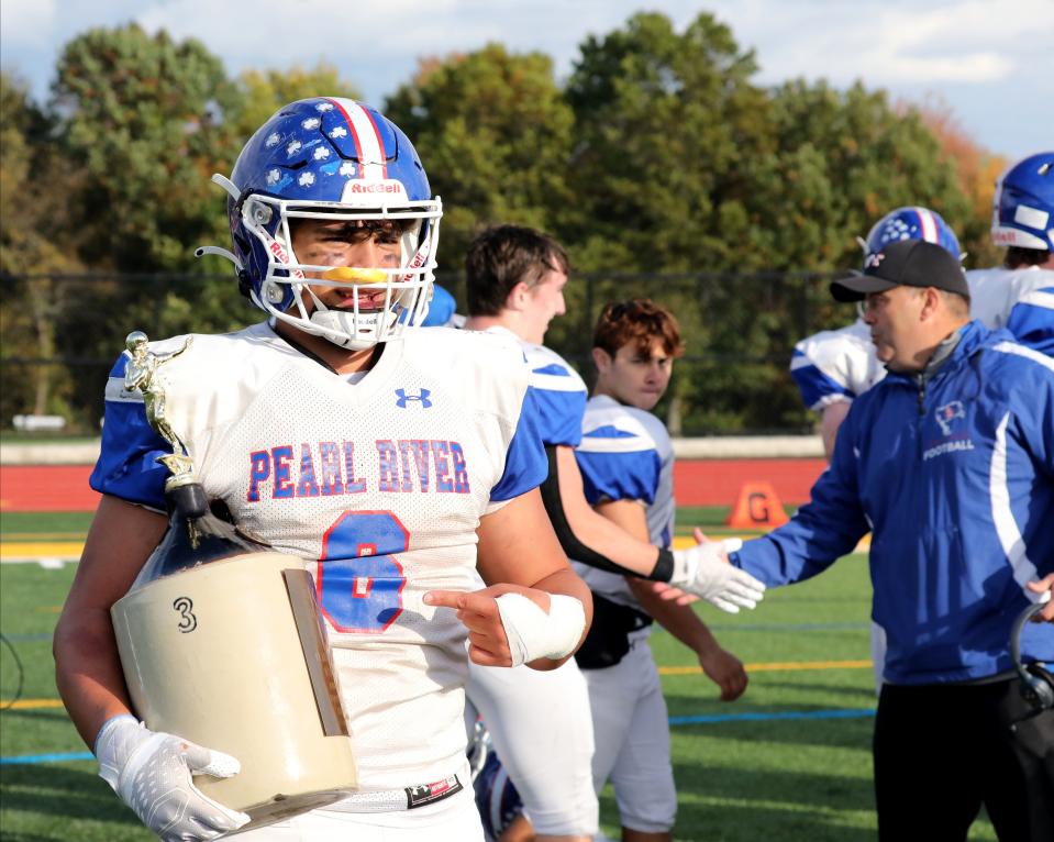 Pearl River's Nicholas Espinal holds the Little Brown Jug after they beat Nanuet 20-17 in their football game at Nanuet High School, Oct. 21, 2023.