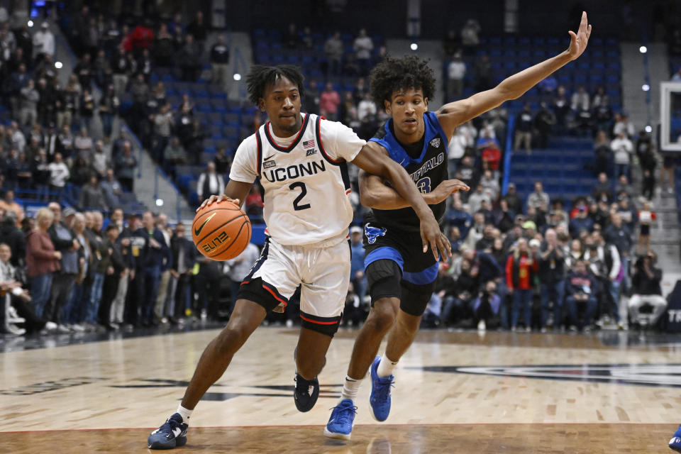 Connecticut's Tristen Newton (2) drives to the basket as Buffalo's Curtis Jones (3) defends in the first half of an NCAA college basketball game, Tuesday, Nov. 15, 2022, in Hartford, Conn. (AP Photo/Jessica Hill)