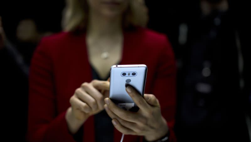 A woman holds the new G6 unveiled by LG as its next phone, ahead of Monday’s opening of the Mobile World Congress wireless show in Barcelona, Spain, Sunday, Feb. 26, 2017. The use of AI boyfriends — and companions — are on the rise.