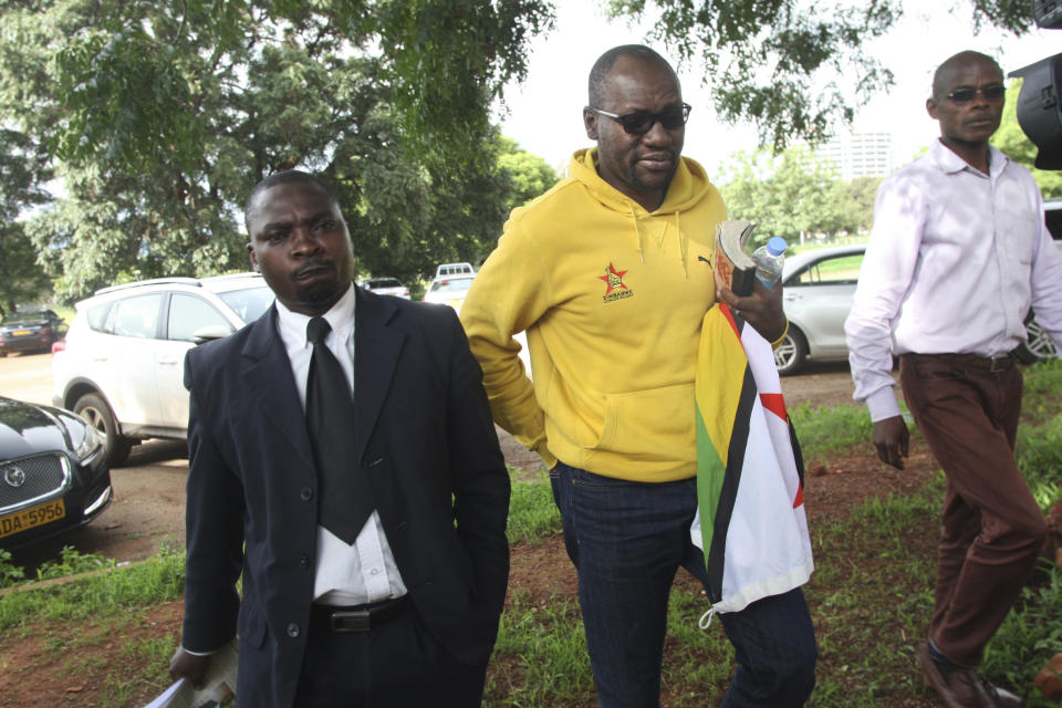 Pastor and activist Evan Mawarire, centre, arrives at the magistrates courts in Harare, Zimbabwe, Thursday, Jan, 17, 2019. A Zimbabwe Lawyers for Human Rights says in a statement that Mawarire who is among the more than 600 people arrested this week has been charged with subverting a constittutional government amid a crackdown on protests against a dramatic fuel price increase.(AP Photo/Tsvangirayi Mukwazhi)