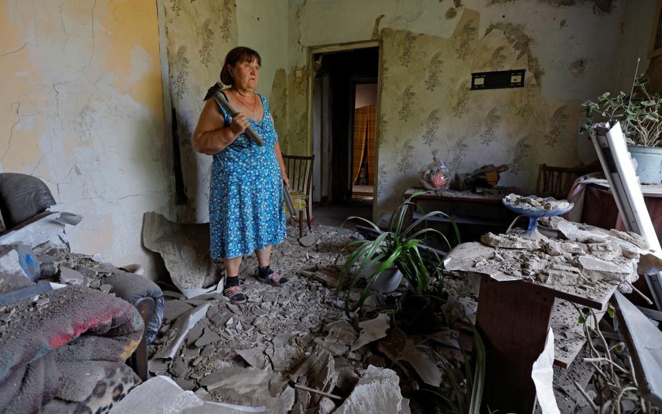 Yelena Gavrish, 65, stands inside her shell-damaged house damaged in the village of Rozivka