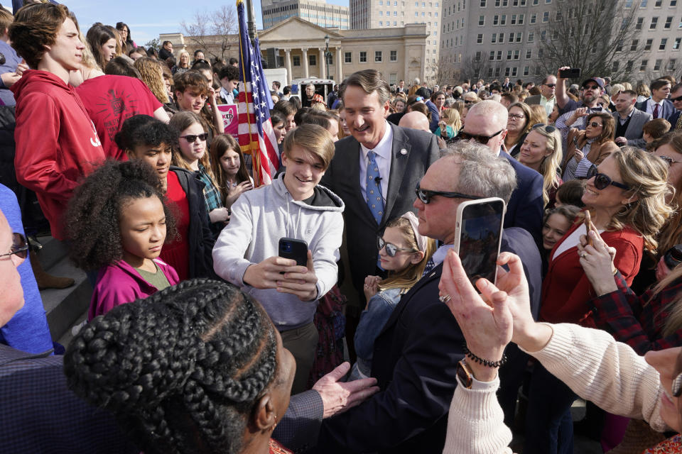 Virginia Gov. Glenn Youngkin, center, poses for photos with school children and parents after signing a bill that bans mask mandates in public schools in Virginia on the steps of the Capitol Wednesday Feb. 16, 2022, in Richmond, Va. (AP Photo/Steve Helber)