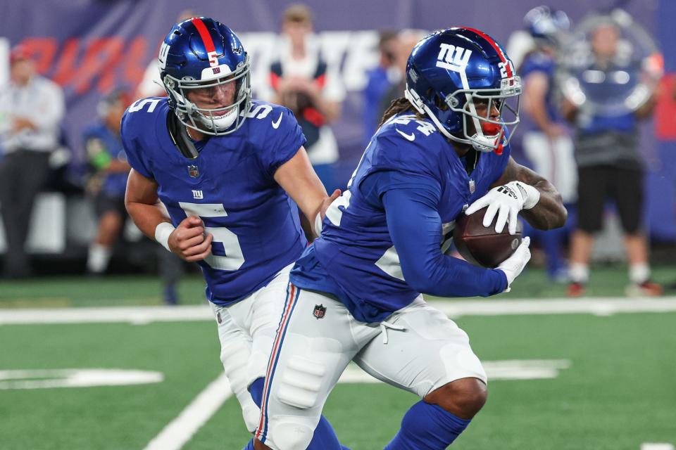 Aug 18, 2023; East Rutherford, New Jersey, USA; New York Giants quarterback Tommy DeVito (5) hands off to running back James Robinson (24) during the second half against the Carolina Panthers at MetLife Stadium. Mandatory Credit: Vincent Carchietta-USA TODAY Sports