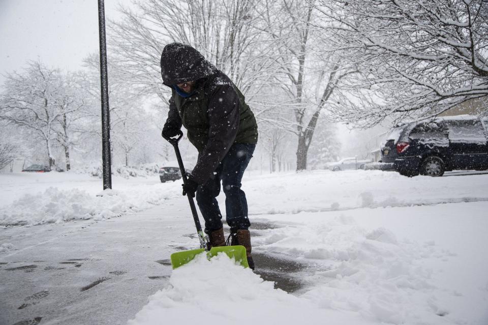 Andy Beverly of Ann arbor shovels the sidewalk and driveway in front of his home in Ann Arbor on Wednesday, Jan. 25, 2023.