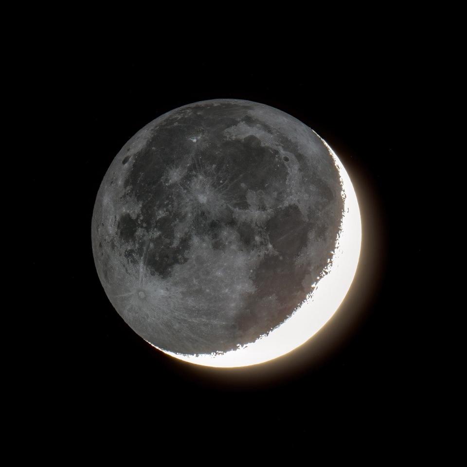 The sunlit portion of the crescent moon is over exposed in this Nov. 16, 2023 photo. The rest of the moon is dimly illuminated by reflected sunlight from Earth or 'earthshine.'