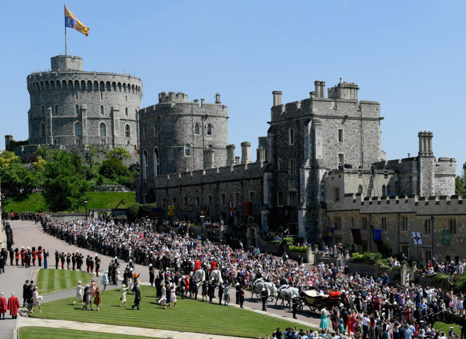 <p>Hundreds of thousands of wellwishers flocked to Windsor Castle to catch a glimpse of the royal couple during the procession. (Photo: Getty) </p>