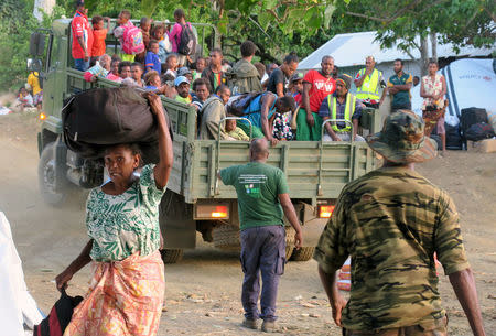 Members of the Vanuatu Mobile Force (VMF) asist residents carrying their possessions as they prepare to board a boat at Lolowai Port as they evacuate due to the Manaro Voui volcano continuing to emenate smoke and ash on Vanuatu's northern island of Ambae in the South Pacific, October 1, 2017. REUTERS/Ben Bohane