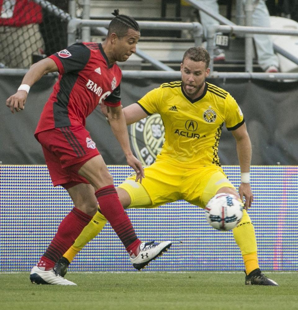 Crew defender Josh Williams tries to stop Toronto FC's Justin Morrow in 2017.