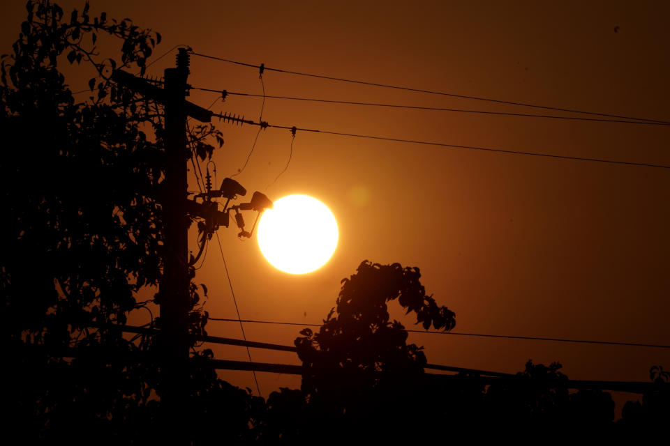 FILE - Sunrise is viewed between power lines in Sacramento, Calif., Thursday, Sept. 8, 2022. The record-breaking heat that has pushed the state's electrical grid to the brink of power outages for more than a week is almost over but it is a sign of things to come. (AP Photo/Rich Pedroncelli, File)