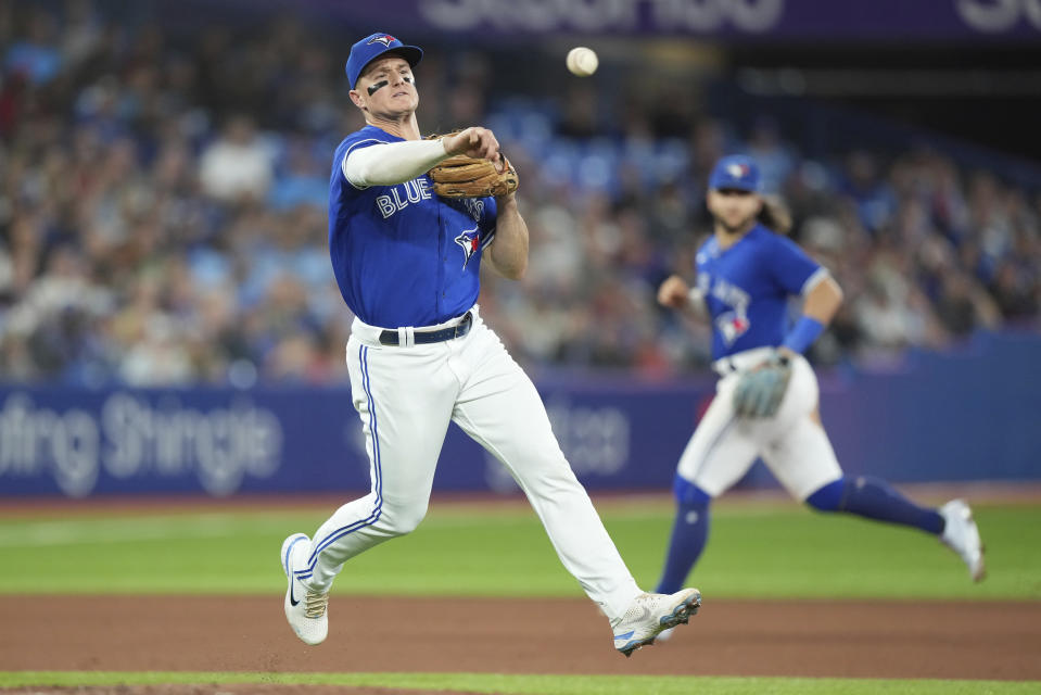 Toronto Blue Jays third baseman Matt Chapman, foreground, throws to first to put out New York Yankees' Isiah Kiner-Falefa during seventh-inning baseball game action in Toronto, Monday, Sept. 26, 2022. (Nathan Denette/The Canadian Press via AP)