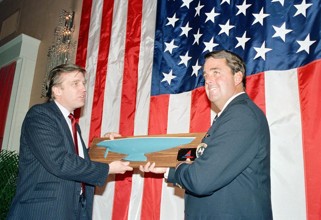 Dennis Conner, right, skipper of "Stars and Stripes," receives a model depicting the hull of his winning yacht from real estate developer Donald Trump during a reception for Conner and his crew in New York on Feb. 10, 1987.
