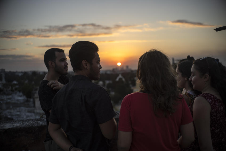 Marcos Marzo, segundo desde la izquierda, habla con sus amigos que vinieron a despedirse de él luego de recibir la noticia de que obtuvo un permiso para viajar a Estados Unidos, en La Habana, Cuba, el miércoles 25 de enero de 2023. (AP Foto/Ramón Espinosa)