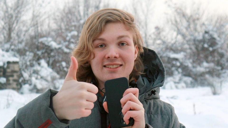 Ada standing in the snow with a warm coat and a cell phone