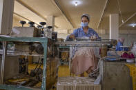 A woman working at Medic Egypt for Medical Clothes company makes protective face masks to be used to help curb the spread of the coronavirus at a factory in Menoufiya, Egypt, Saturday, June 6, 2020. Egypt has officially ordered its people to wear face masks in public and private transportation, inside government business and offices as it is easing the partial lockdown imposed. Prime Minister Mustafa Madbouly has said violators would be fined as the country has seen a jump of daily reported infections in the past week. (AP Photo/Nariman El-Mofty)