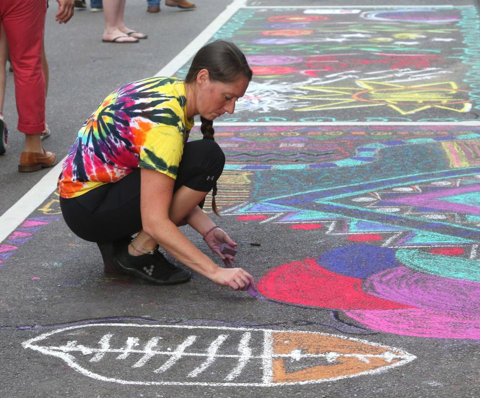 Staci Becker works on her chalk drawing during First Friday in Canton on Friday, July 2, 2021. The theme for the July 2022 First Friday is "Chalk the Walk."