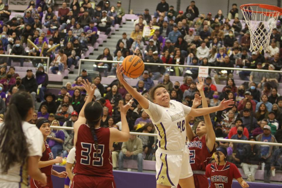 Kirtland Central's Aaryanna Lansing reaches for a rebound while being contested by Deming's Moniqa Enciso (33) and Natalie Ramirez (2) after a missed shot during the second quarter of a first round Class 4A state tournament game, Friday, March 3, 2023 at Bronco Arena.