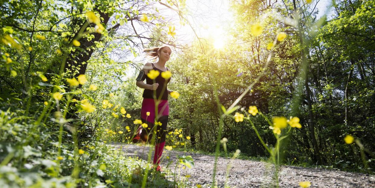 young sporty woman jogging through the forest