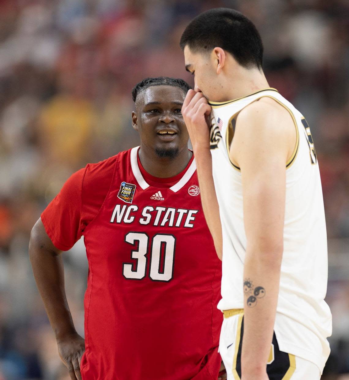 N.C. State’s D.J. Burns Jr. (30) has a conversation with Purdue’s Zach Edey (15) as they wait for play to resume during the first half in the NCAA Final Four National Semifinal game on Saturday, April 6, 2024 at State Farm Stadium in Glendale, AZ. Robert Willett/rwillett@newsobserver.com