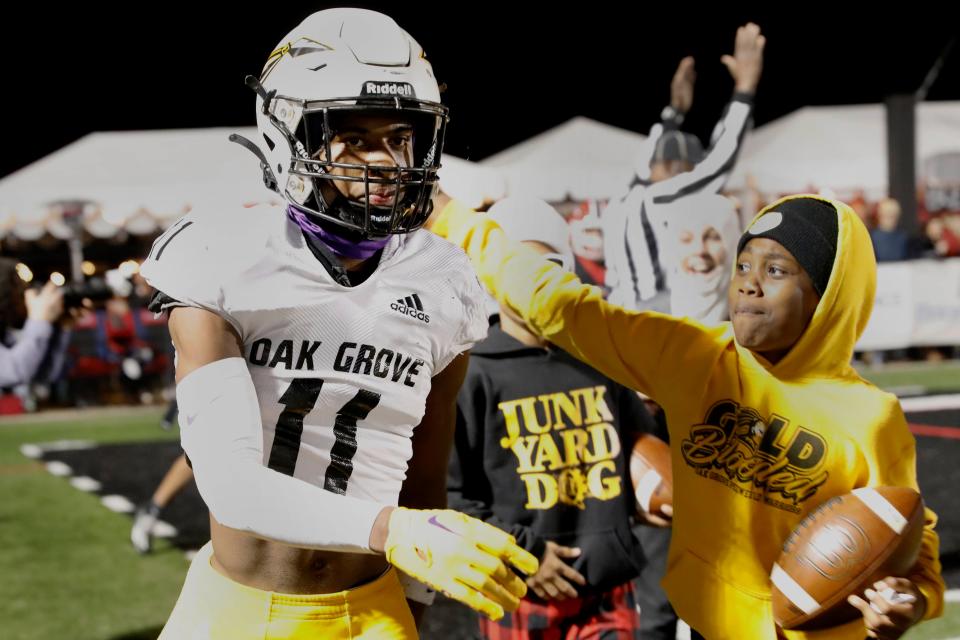 Young fans pat Oak Grove High School WR Pj Woodland (11) on the back after his touchdown during the 7A tournament game against Brandon High School at Bulldog Stadium on Saturday, Nov. 24, 2023 in Brandon, MS.