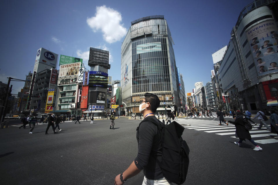 Fewer than usual people at Shibuya Scramble Crossing is seen Wednesday, April 8, 2020, in Tokyo. Japanese Prime Minister Shinzo Abe declared a state of emergency Tuesday for Tokyo and six other prefectures to ramp up defenses against the spread of the coronavirus. (AP Photo/Eugene Hoshiko)