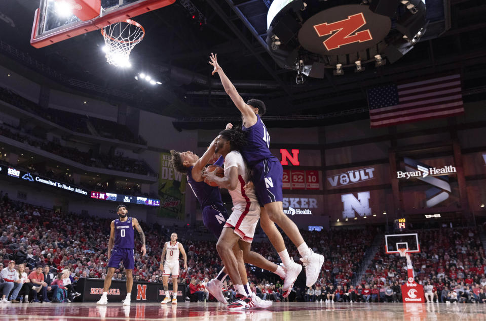 Nebraska's Derrick Walker, center, collides with Northwestern's Ty Berry, left, and Tydus Verhoeven while driving to the basket during the first half of an NCAA college basketball game Wednesday, Jan. 25, 2023, in Lincoln, Neb. (AP Photo/Rebecca S. Gratz)