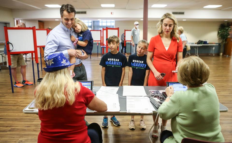 Ky. state senator and U.S. congress candidate Morgan McGarvey holds daughter Greta as his son Wilson, center, daughter Clara and wife Chris check in to vote at Immanuel United Church of Christ on Taylorsville Road Tuesday morning. May 17, 2022