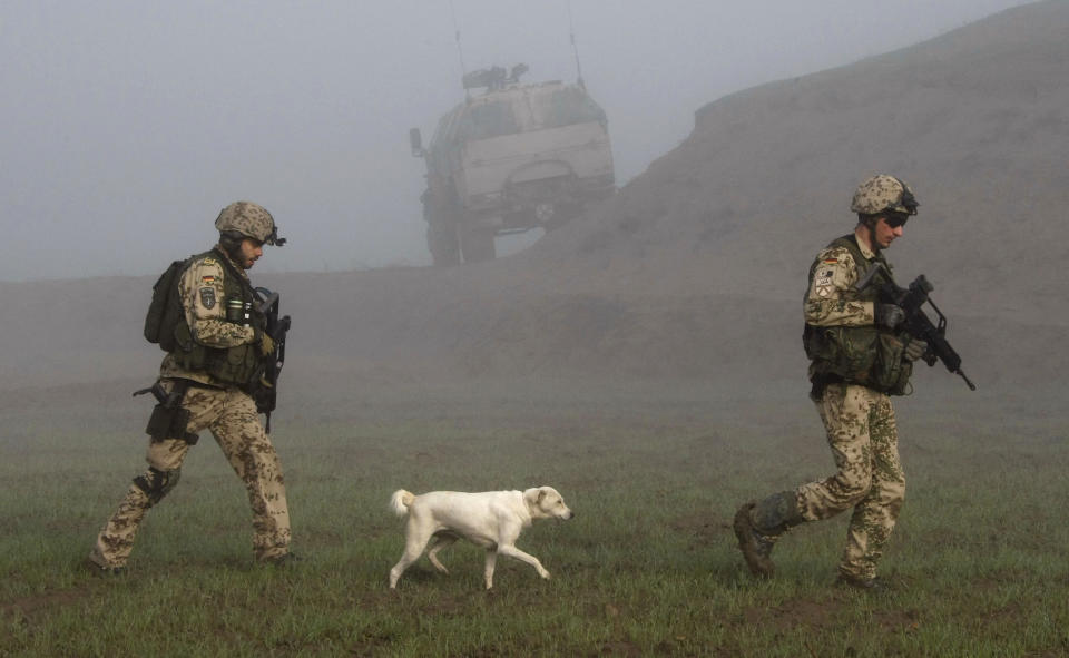 A dog follows German Bundeswehr army soldiers of the International Security Assistance Force (ISAF) during a mission in Chahar Dara