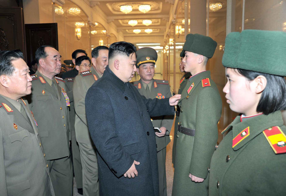 This undated photo released by North Korea's official Korean Central News Agency (KCNA) via the Korean News Service (KNS) on March 25, 2013 shows North Korean leader Kim Jong-Un (C) looking at the samples of overcoats at an undisclosed location in North Korea.&nbsp;