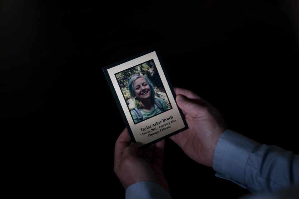 Harry Bruell holds a framed photo of his daughter, Taya, while sitting for a photo in his office in Santa Barbara, Calif., Wednesday, March 9, 2022. Taya killed herself when she was 14. Taya was a bright, precocious student who had started struggling with mental health issues at about 11, according to her father. At the time, the family lived in Boulder, Colorado where Taya was hospitalized at one point for psychiatric care but kept up the trappings of a model student. (AP Photo/Jae C. Hong)