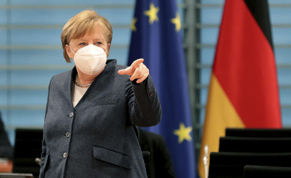 German Chancellor Angela Merkel points as she arrives for the weekly cabinet meeting at the Chancellery in Berlin, Germany, Wednesday, Feb. 3, 2021. (AP Photo/Michael Sohn, pool)