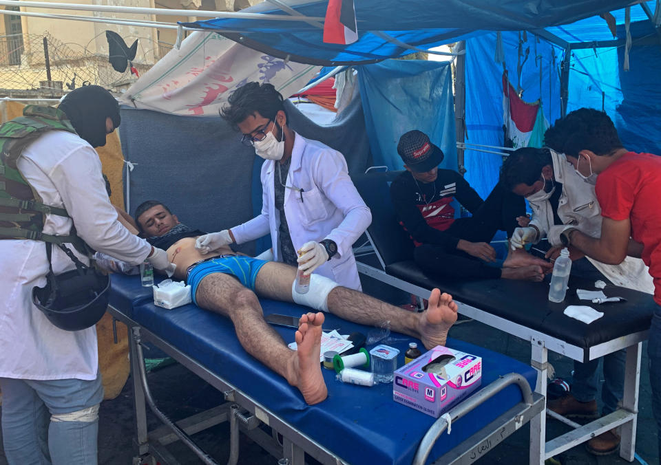 Protesters receive treatment at Tahrir Square in Baghdad, Iraq, Thursday, Nov. 21, 2019. Renewed clashes overnight in Baghdad between anti-government demonstrators and security forces killed and wounded protesters, security and hospital officials said Thursday. (AP Photo/Ali Abdul Hassan)