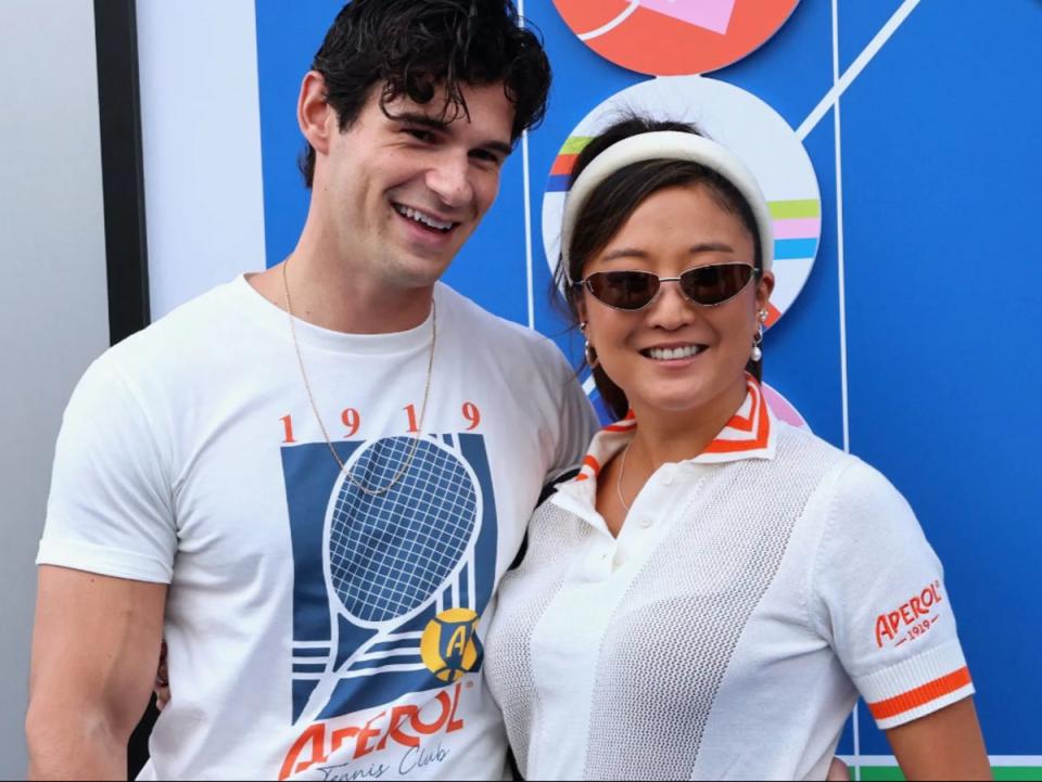 ‘Emily in Paris’ stars and real-life couple Ashley Park and Paul Forman don Aperol Spritz x US Open merch for the tournament (Guerin Charles/ABACA/Shutterstock)