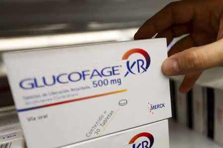 A worker of a drugstore holds a packet of medicine from pharmaceutical company Merck at a drugstore in Caracas May 6, 2015. REUTERS/Carlos Garcia Rawlins