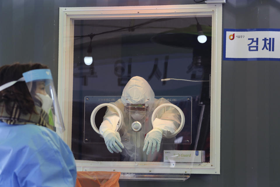 A medical worker in a booth rests during COVID-19 testing at a makeshift clinic in Seoul, South Korea, Saturday, Jan. 2, 2021. South Korea is extending stringent distancing rules for two more weeks as authorities seek to suppress a viral resurgence, while confirming its first case of an apparently more contagious coronavirus variant detected in South Africa. (AP Photo/Ahn Young-joon)