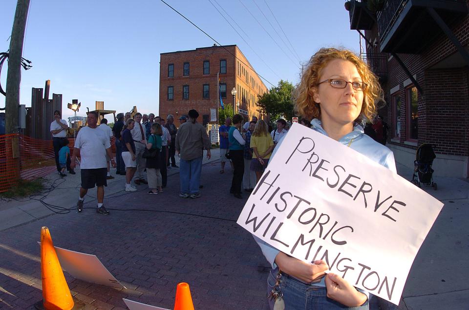 Downtown Wilmington resident Helen Greaves-Williams holds a sign in favor of preserving historic Wilmington as work crews tear down the Ice House early Monday, April 26, 2004. An estimated crowd of 60 came out witness the demolition of the historic Water Street building.