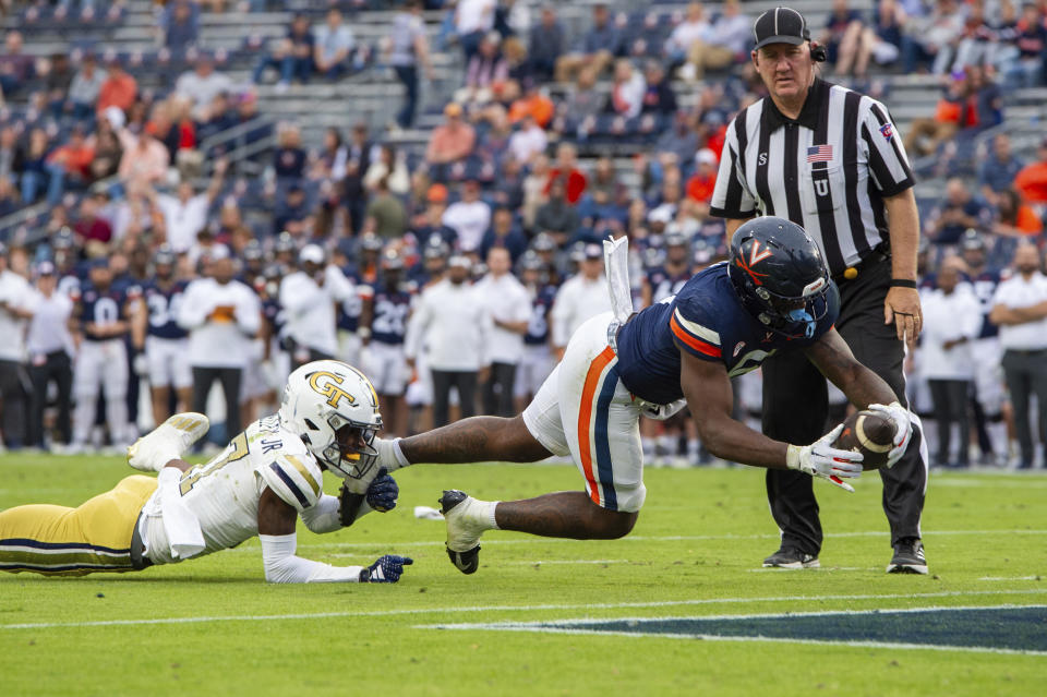 Virginia running back Kobe Pace (5) dives in for a touchdown as he is tackled by Georgia Tech defensive back Rodney Shelley (17) during the second half of an NCAA college football game Saturday, Nov. 4, 2023, in Charlottesville, Va. (AP Photo/Mike Caudill)