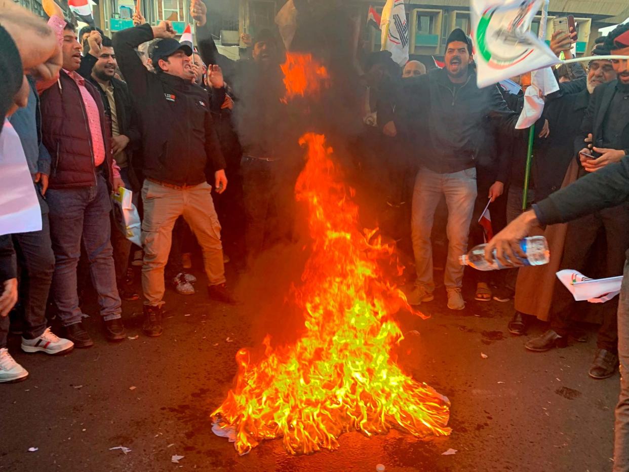 Protesters burn a representation of a US flag during a protest against the airstrikes on Kataeb Hezbollah: AP