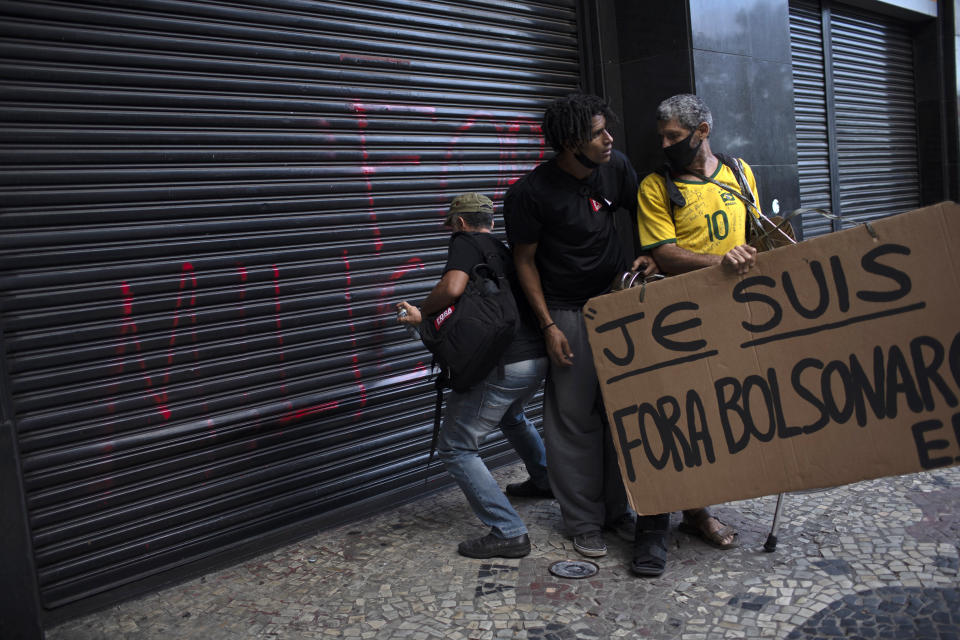 A demonstrator defaces a security gate at the Military Club during a protest against the Brazilian President Jair Bolsonaro coinciding with the anniversary of the 1964 military coup that established a decades-long dictatorship, in Rio de Janeiro, Brazil, Wednesday, March 31, 2021. The leaders of all three branches of Brazil’s armed forces have jointly resigned following Bolsonaro’s replacement of the defense minister, that is causing widespread apprehension of a military shakeup to serve the president’s political interests. (AP Photo/Silvia Izquierdo)