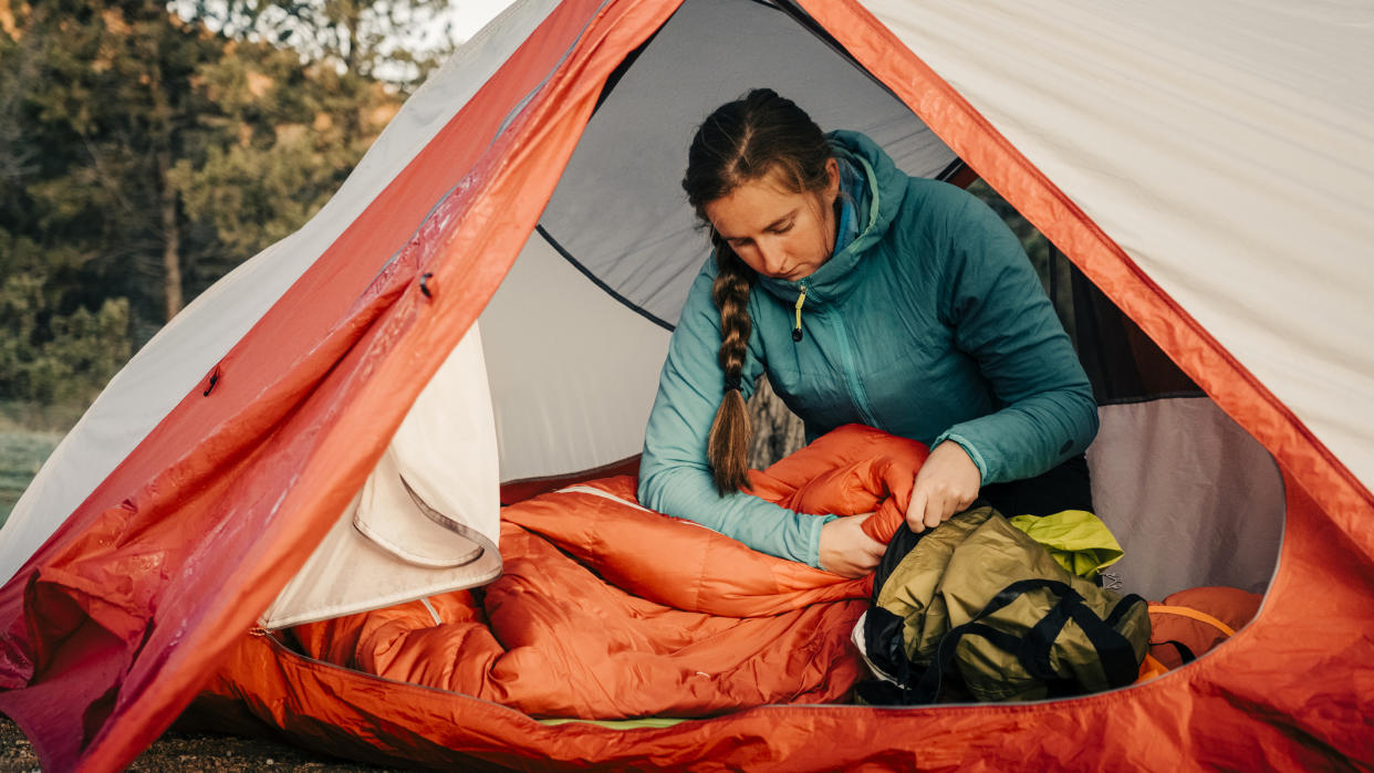  How to wash a sleeping bag: woman sorting bag. 