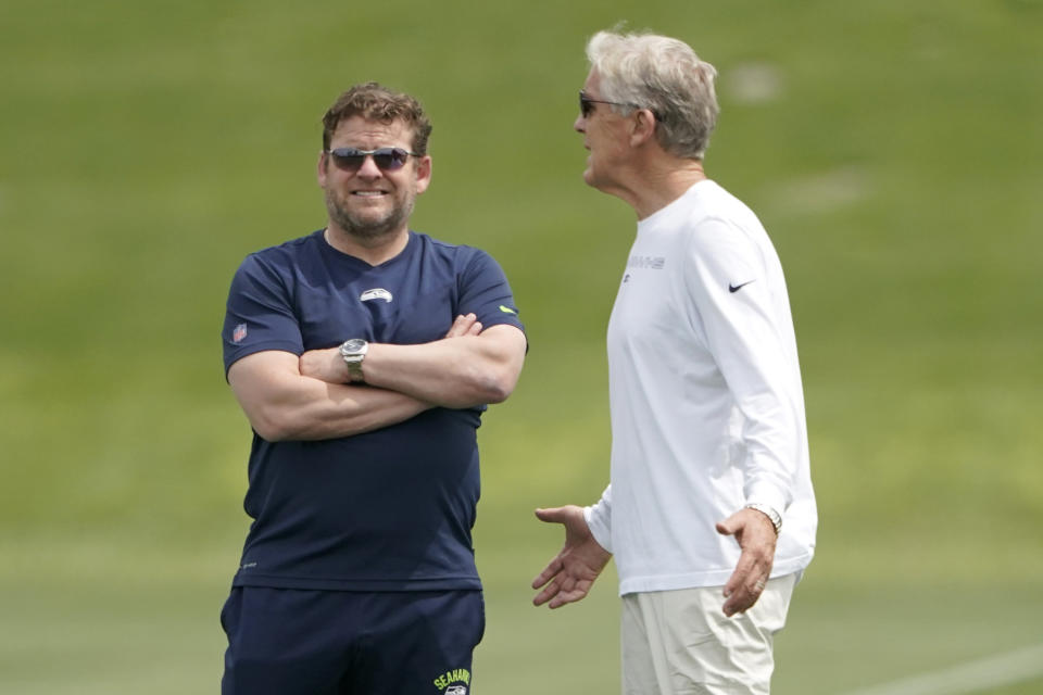 Seattle Seahawks general manager John Schneider, left, talks with coach Pete Carroll during NFL football practice Tuesday, June 7, 2022, in Renton, Wash. (AP Photo/Ted S. Warren)
