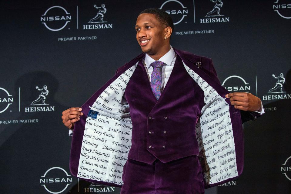 Washington quarterback Michael Penix Jr. shows the inside of his jacket that has his teammates' names ahead of the 2023 Heisman Trophy ceremony; Penix finished No. 2 in the voting.